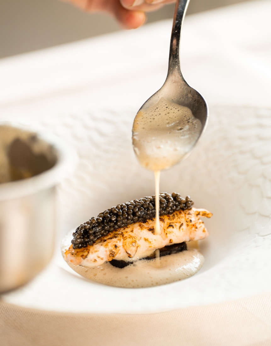 Er wordt saus over een gerecht met kaviaar geschonken